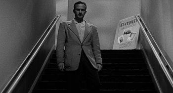 Movie still from “Marty” (1955), directed by Delbert Mann – A black and white photo of a man standing on a staircase; Medium shot, Low angle