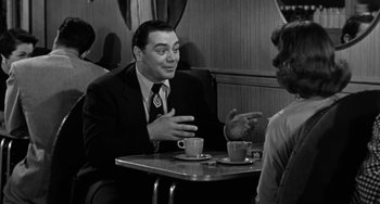 Movie still from “Marty” (1955), directed by Delbert Mann – A man sitting at a table talking to a woman in front of him; Medium shot, Over the shoulder angle
