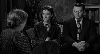 Movie still from “Marty” (1955), directed by Delbert Mann – A woman sitting next to two men in a living room; Medium shot, Over the shoulder angle