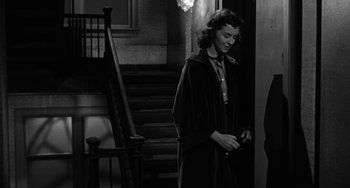 Movie still from “Marty” (1955), directed by Delbert Mann – A woman standing in front of a set of stairs; Medium shot, Low angle