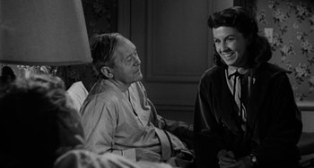 Movie still from “Marty” (1955), directed by Delbert Mann – A man and a woman sitting next to each other in a room; Medium shot, Over the shoulder angle