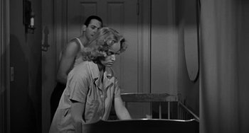 Movie still from “Marty” (1955), directed by Delbert Mann – A man and a woman standing next to a baby crib; Medium shot, Over the shoulder angle
