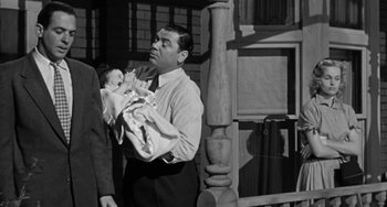 Movie still from “Marty” (1955), directed by Delbert Mann – A man holding a baby in his arms while standing next to another man; Medium shot, Over the shoulder angle