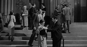 Movie still from “Marty” (1955), directed by Delbert Mann – An old photo of a man and a woman on the steps; Wide shot, High angle