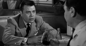 Movie still from “Marty” (1955), directed by Delbert Mann – A man sitting at a table with a glass of wine in front of him; Close Up shot, Over the shoulder angle