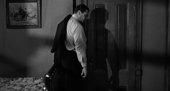 Movie still from “Marty” (1955), directed by Delbert Mann – A black and white photo of a man standing in front of a door; Medium shot, High angle