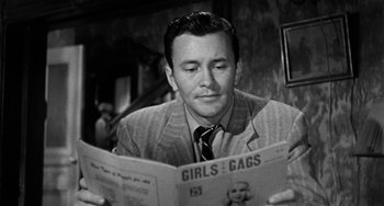 Movie still from “Marty” (1955), directed by Delbert Mann – A black and white photo of a man reading a newspaper; Close Up shot, Over the shoulder angle