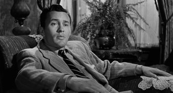 A black and white photo of a man sitting in a chair