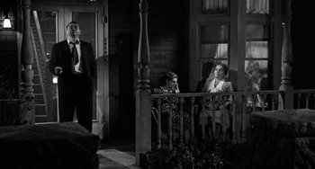 Movie still from “Marty” (1955), directed by Delbert Mann – A black and white photo of a man and a woman sitting on a porch; Wide shot, Low angle