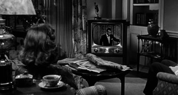 Movie still from “Marty” (1955), directed by Delbert Mann – An old tv sitting on top of a wooden table in a living room; Medium shot, High angle