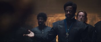 Movie still from “Mary Queen of Scots” (2018), directed by Josie Rourke – Two men standing next to each other in a dark room; Medium shot, Over the shoulder angle
