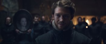 Movie still from “Mary Queen of Scots” (2018), directed by Josie Rourke – A person wearing a black jacket; Close Up shot, Over the shoulder angle