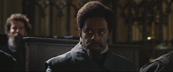 Movie still from “Mary Queen of Scots” (2018), directed by Josie Rourke – A person with a beard wearing a suit; Close Up shot, Over the shoulder angle