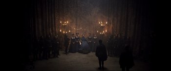 Movie still from “Mary Queen of Scots” (2018), directed by Josie Rourke – A group of people standing in a room with candles; Wide shot, High angle