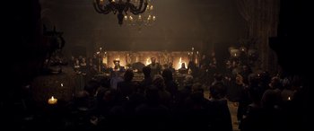 Movie still from “Mary Queen of Scots” (2018), directed by Josie Rourke – A group of people sitting in front of a fireplace; Wide shot, High angle