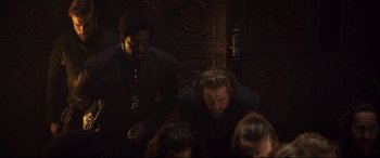 Movie still from “Mary Queen of Scots” (2018), directed by Josie Rourke – Two men are sitting in a dark room; Medium shot, High angle
