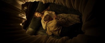 Movie still from “Mary Queen of Scots” (2018), directed by Josie Rourke – A woman and a child laying on a bed; Medium shot, Overhead angle