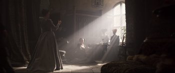 Movie still from “Mary Queen of Scots” (2018), directed by Josie Rourke – A group of people sitting in a room with a window; Wide shot, Low angle