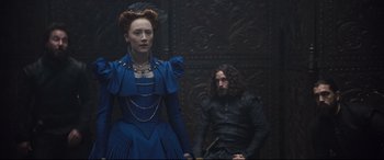 Movie still from “Mary Queen of Scots” (2018), directed by Josie Rourke – A man and a woman dressed in medieval garb in front of a wall; Medium shot, Over the shoulder angle
