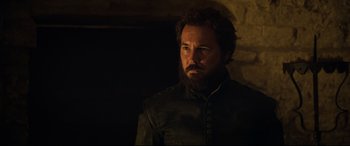 Movie still from “Mary Queen of Scots” (2018), directed by Josie Rourke – A man with a beard and a black jacket; Close Up shot, Over the shoulder angle