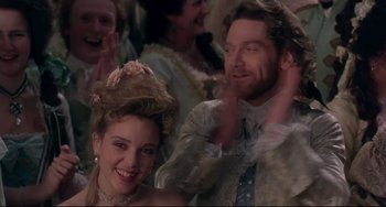 Movie still from “Frankenstein” (1994), directed by Kenneth Branagh – A man and a woman are smiling in a crowd of people; Medium shot, Over the shoulder angle