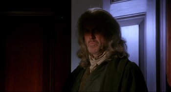 Movie still from “Frankenstein” (1994), directed by Kenneth Branagh – A man with long hair is standing in front of a window; Medium shot, Over the shoulder angle