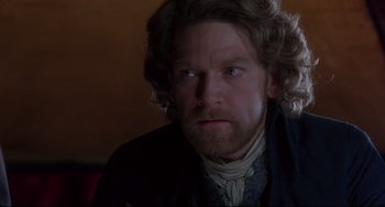 Movie still from “Frankenstein” (1994), directed by Kenneth Branagh – A person wearing a suit and a beard; Close Up shot, Over the shoulder angle
