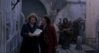 Movie still from “Frankenstein” (1994), directed by Kenneth Branagh – Two people standing next to each other on a street; Medium shot, Over the shoulder angle
