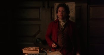 Movie still from “Frankenstein” (1994), directed by Kenneth Branagh – A man standing in a room next to a table; Medium shot, Low angle