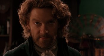 Movie still from “Frankenstein” (1994), directed by Kenneth Branagh – A person with a beard and curly hair; Close Up shot, Over the shoulder angle