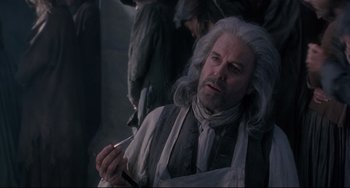 Movie still from “Frankenstein” (1994), directed by Kenneth Branagh – An old man with long white hair is holding a cigarette in his mouth; Medium shot, Low angle