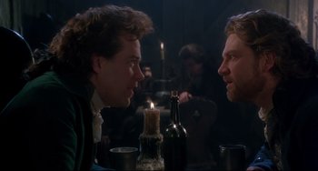 Movie still from “Frankenstein” (1994), directed by Kenneth Branagh – Two men sitting at a table with a lit candle in front of them; Medium shot, Over the shoulder angle