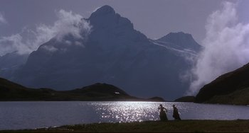 Movie still from “Frankenstein” (1994), directed by Kenneth Branagh – Two people sitting on the shore of a body of water; Extreme Wide shot, Low angle