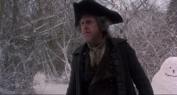 Movie still from “Frankenstein” (1994), directed by Kenneth Branagh – An old man in a hat and a coat standing in the snow near a tree; Medium shot, Low angle