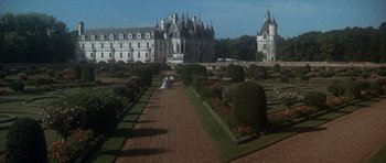 Movie still from “Mary, Queen of Scots” (1971), directed by Charles Jarrott – Two people sitting on a bench in front of a castle; Extreme Wide shot, High angle