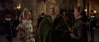 Movie still from “Mary, Queen of Scots” (1971), directed by Charles Jarrott – Two women in medieval garb standing in front of a stone wall; Medium shot, Over the shoulder angle
