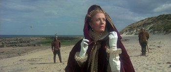Movie still from “Mary, Queen of Scots” (1971), directed by Charles Jarrott – A woman in a medieval costume standing on a beach; Medium shot, Low angle