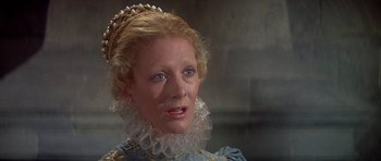 Movie still from “Mary, Queen of Scots” (1971), directed by Charles Jarrott – An older woman wearing a blue dress and a crown; Close Up shot, High angle