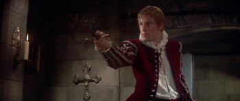 Movie still from “Mary, Queen of Scots” (1971), directed by Charles Jarrott – A man dressed in medieval clothing holding a sword; Medium shot, Low angle