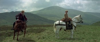 Movie still from “Mary, Queen of Scots” (1971), directed by Charles Jarrott – A woman riding on the back of a white horse in a field; Wide shot, Low angle