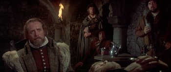 Movie still from “Mary, Queen of Scots” (1971), directed by Charles Jarrott – Two men in medieval garb sitting in front of a fireplace; Medium shot, Over the shoulder angle