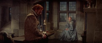 Movie still from “Mary, Queen of Scots” (1971), directed by Charles Jarrott – A man and a woman sitting in front of a lit candle; Wide shot, High angle