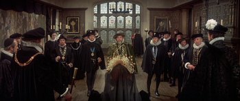 Movie still from “Mary, Queen of Scots” (1971), directed by Charles Jarrott – A group of people in a room with stained glass windows; Wide shot, High angle
