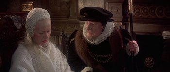 Movie still from “Mary, Queen of Scots” (1971), directed by Charles Jarrott – An older man in a fur coat and a hat; Close Up shot, Over the shoulder angle