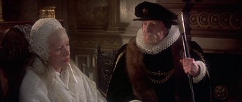 Movie still from “Mary, Queen of Scots” (1971), directed by Charles Jarrott – A man wearing a hat and a fur coat; Close Up shot, Over the shoulder angle
