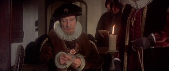 Movie still from “Mary, Queen of Scots” (1971), directed by Charles Jarrott – An old man wearing a hat and a fur coat; Medium shot, Over the shoulder angle