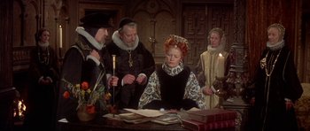 Movie still from “Mary, Queen of Scots” (1971), directed by Charles Jarrott – A group of men and women standing around a table; Medium shot, High angle