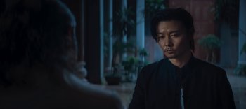 Movie still from “Master Z: The Ip Man Legacy” (2018), directed by Woo-Ping Yuen – A man sitting in front of another man in front of a building; Close Up shot, Over the shoulder angle