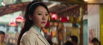 Movie still from “Master Z: The Ip Man Legacy” (2018), directed by Woo-Ping Yuen – A woman in a tan jacket and a blue headband; Close Up shot, Low angle