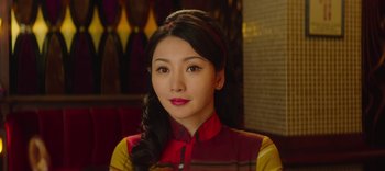Movie still from “Master Z: The Ip Man Legacy” (2018), directed by Woo-Ping Yuen – A woman in a cheongsam is posing for a picture; Close Up shot, Over the shoulder angle